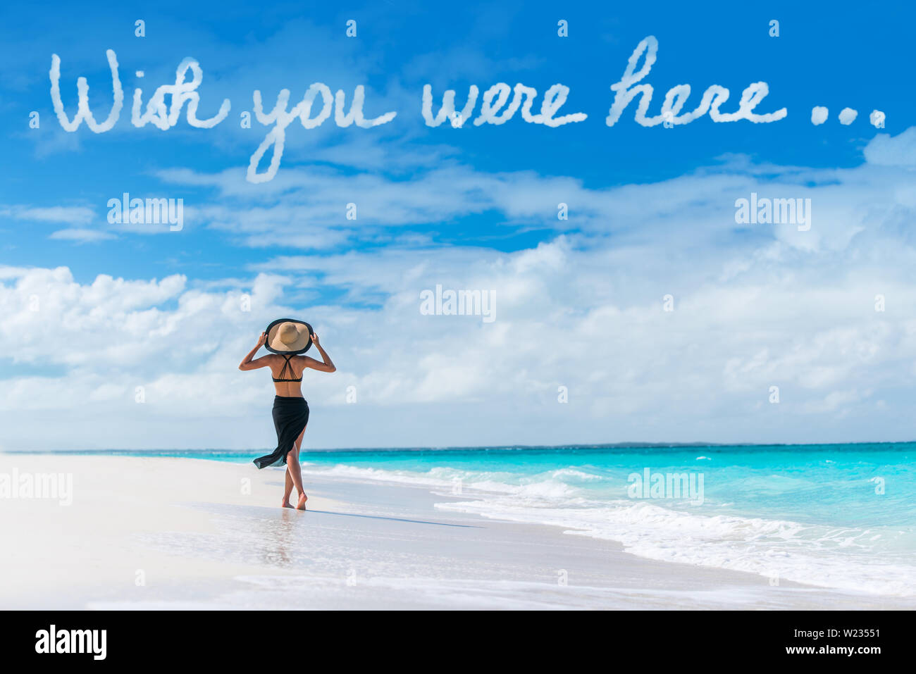 Wish You Were Here cloud message écrit dans le ciel au-dessus de woman  walking on beach vacation Luxury Travel destination des Caraïbes. Détente  Tourisme sur des vacances à resort. Proverbe populaire carte
