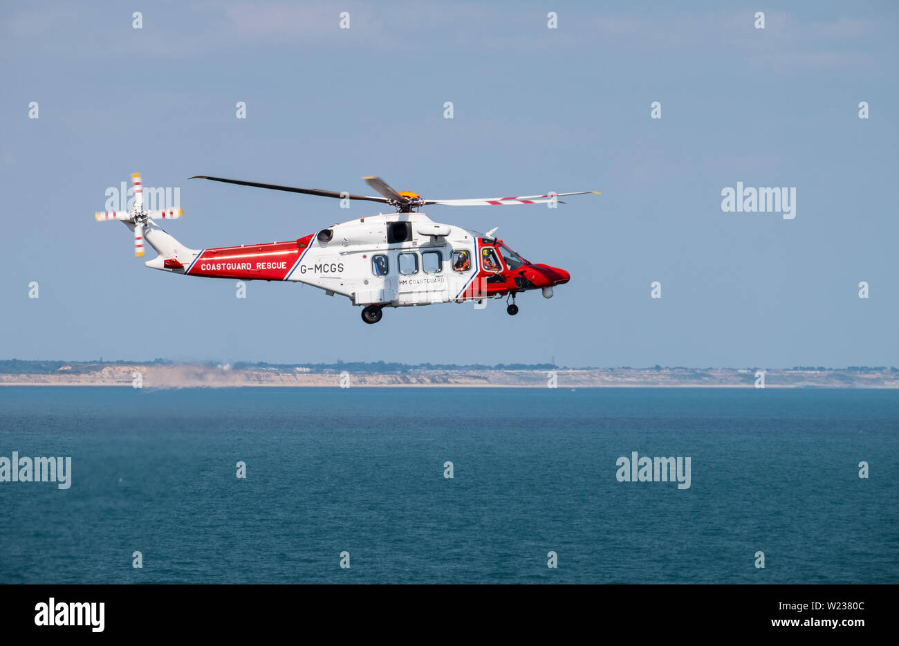 HM Coastguard Hélicoptère survolant la côte du Dorset Banque D'Images