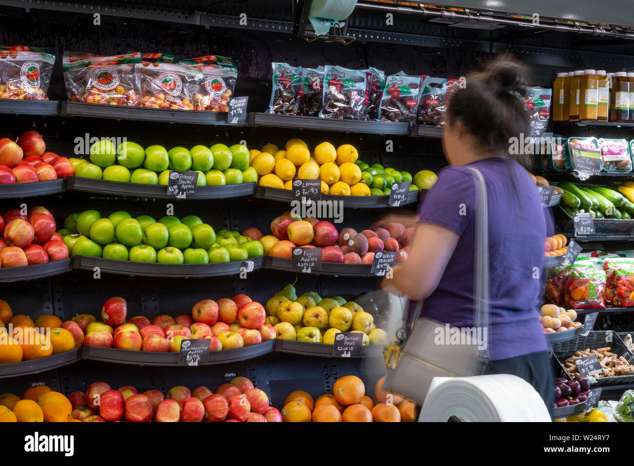Femme l'achat des fruits dans une épicerie, USA Banque D'Images