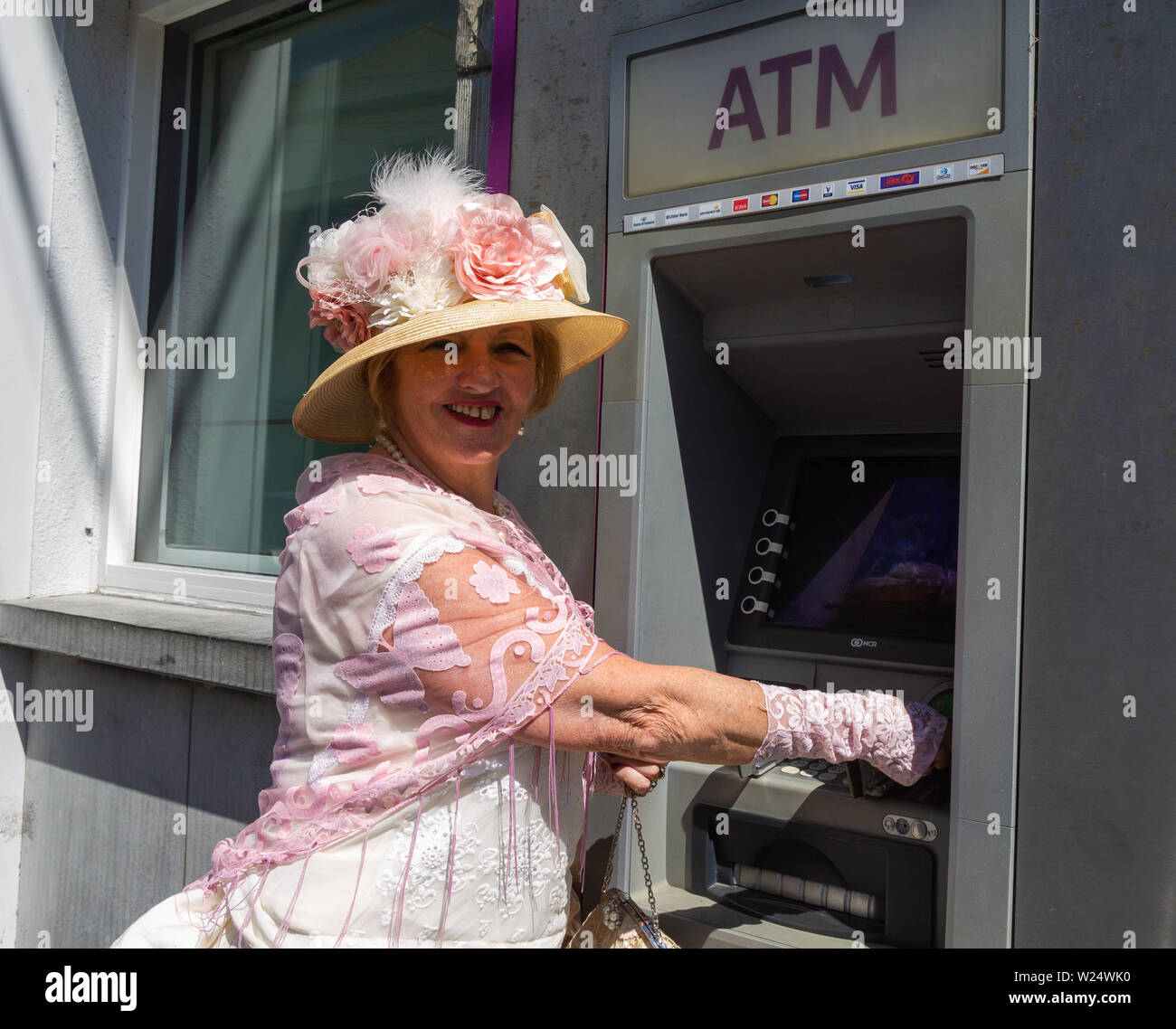 Femme portant des vêtements de style victorien à l'aide de vieux concept  ATM par rapport au nouveau voyage Photo Stock - Alamy