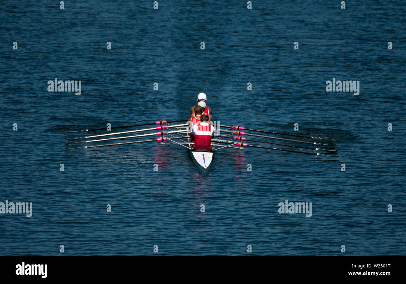 Quatre rameurs dans un bateau de course Quad avec course Oar synchrone Banque D'Images Quatre rameurs dans un bateau de course Quad avec course Oar synchrone Banque D'Images