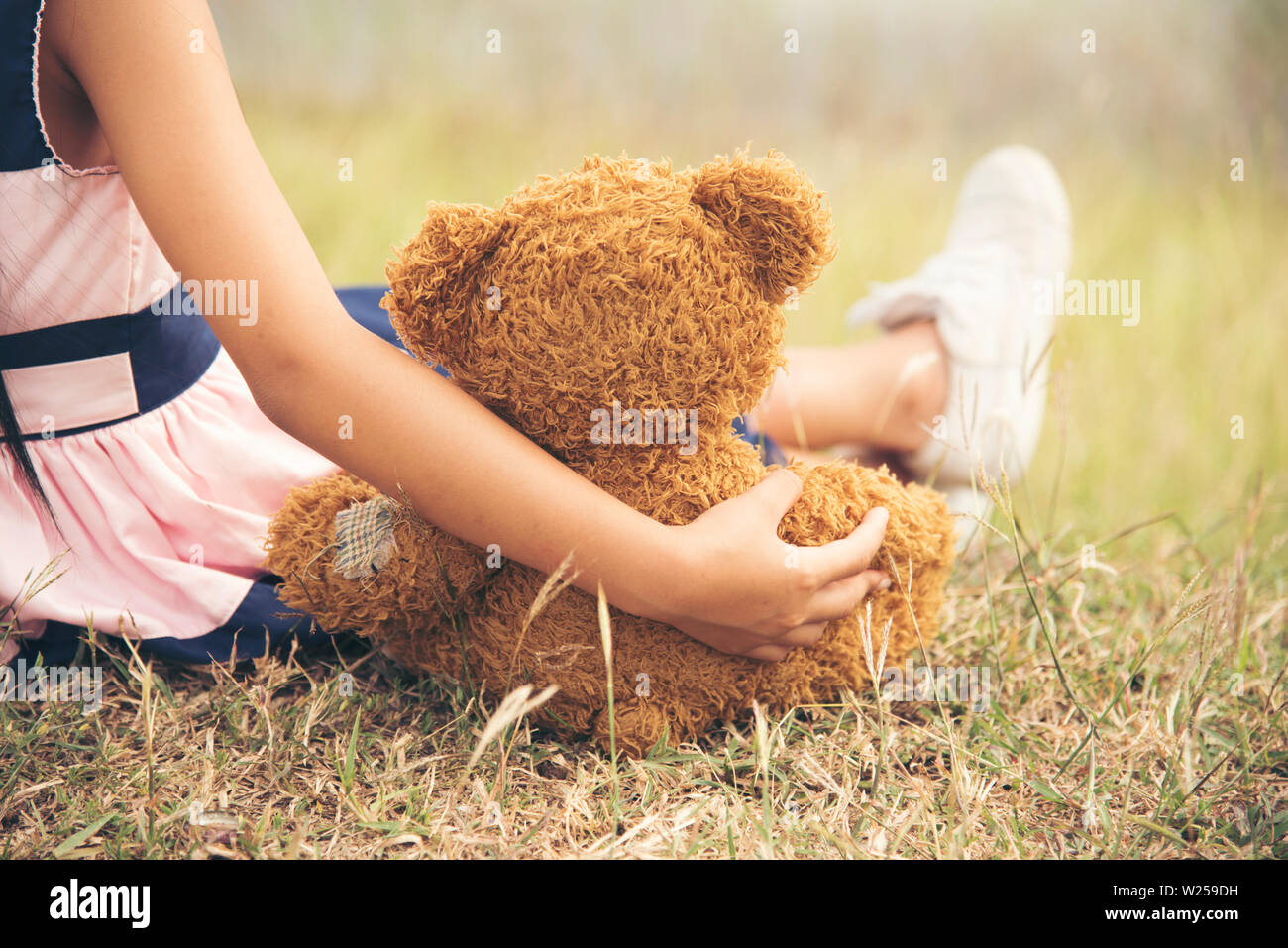 Little girl hugging a fluffy teddy bear Banque D'Images