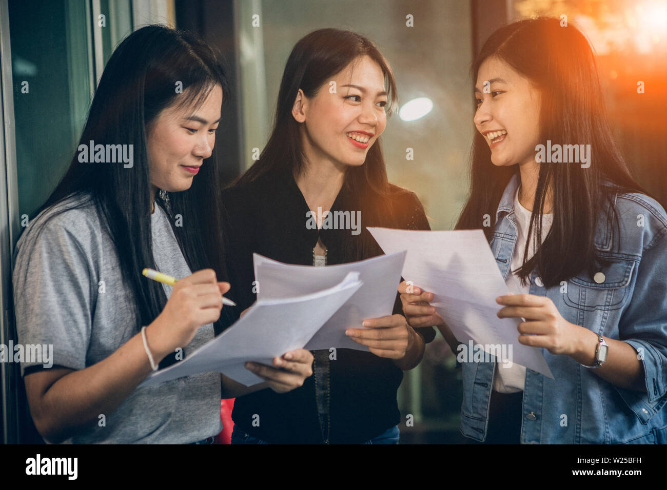 Jeune femme d'Asie offres de parler avec un visage souriant à pleines dents in home office Banque D'Images