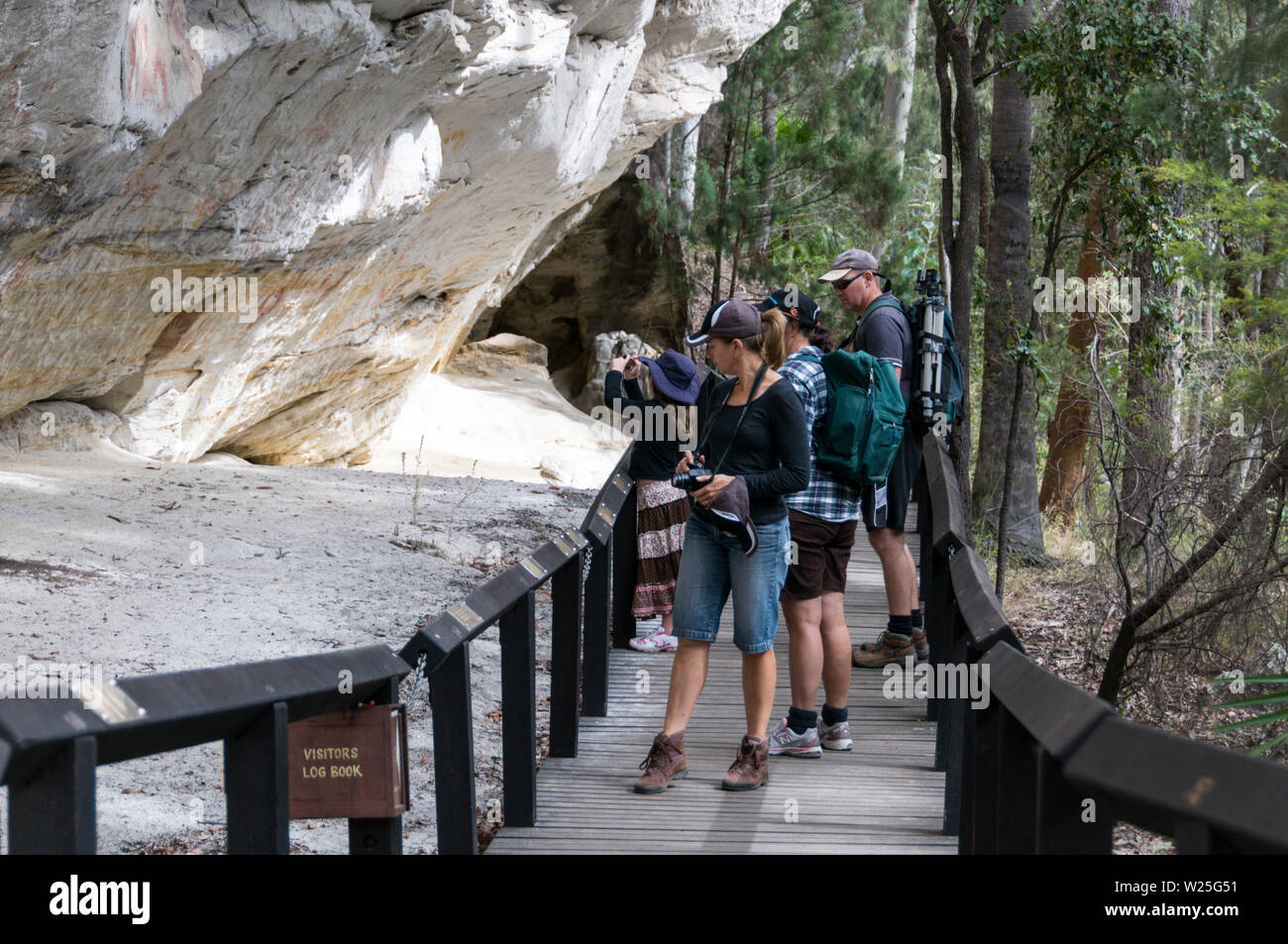 Les visiteurs du bien conservé Aboriginal Rock Art stencil site, connu sous le nom de "Art Gallery" que l'on croit être 3 650 ans sur le rocher de grès blanc Banque D'Images