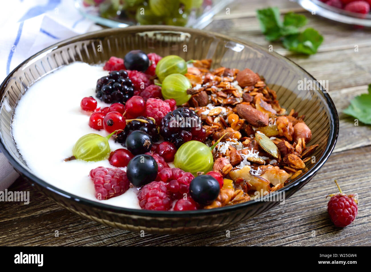 Yaourts, céréales, fruits frais dans un bol sur une table en bois. Petit-déjeuner délicieux et sains. Une bonne nutrition. Menu diététique. Banque D'Images