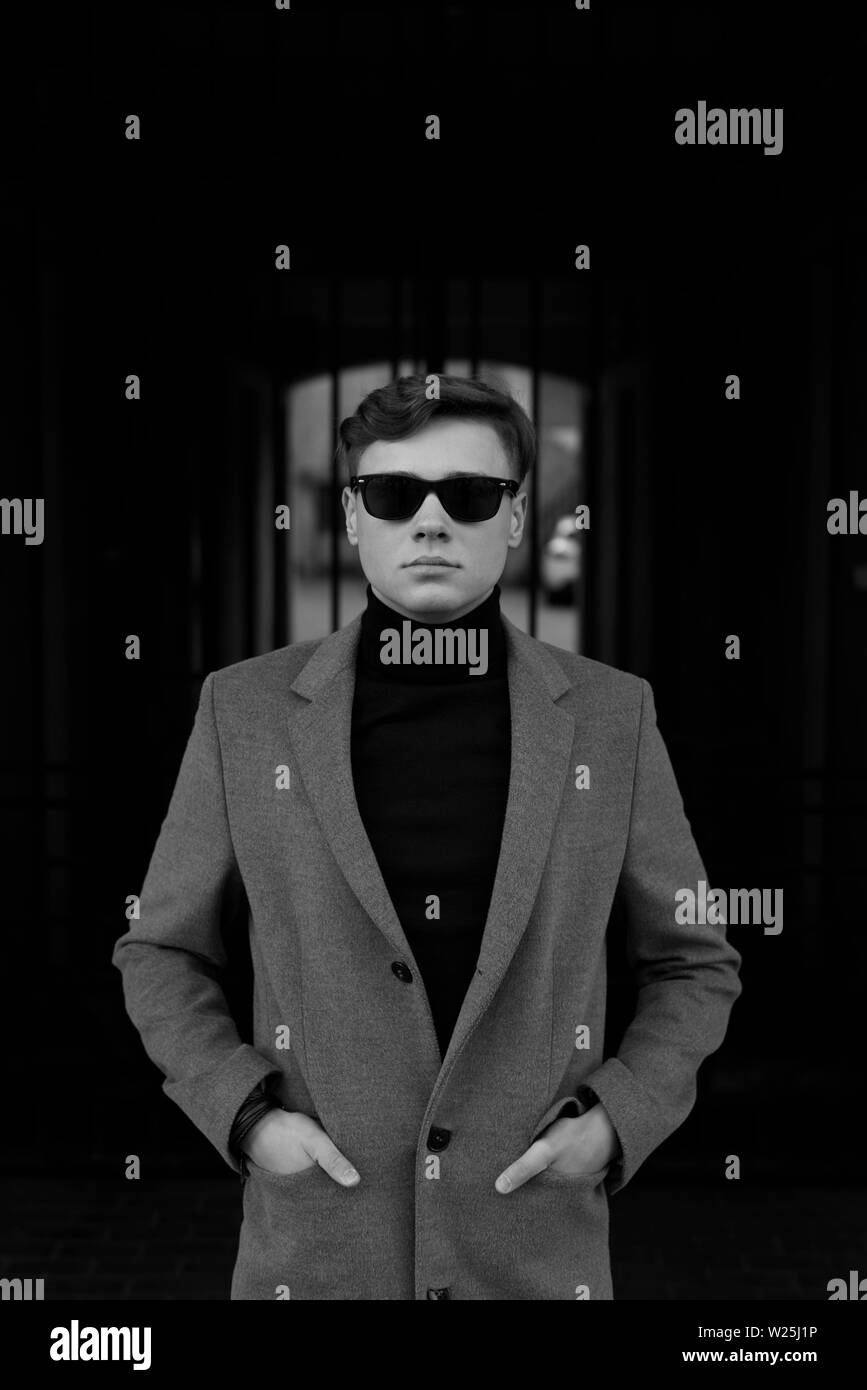 Portrait noir et blanc de l'homme avec un style chic et décontracté. Lunettes de soleil, veste col polo et élégant. Banque D'Images