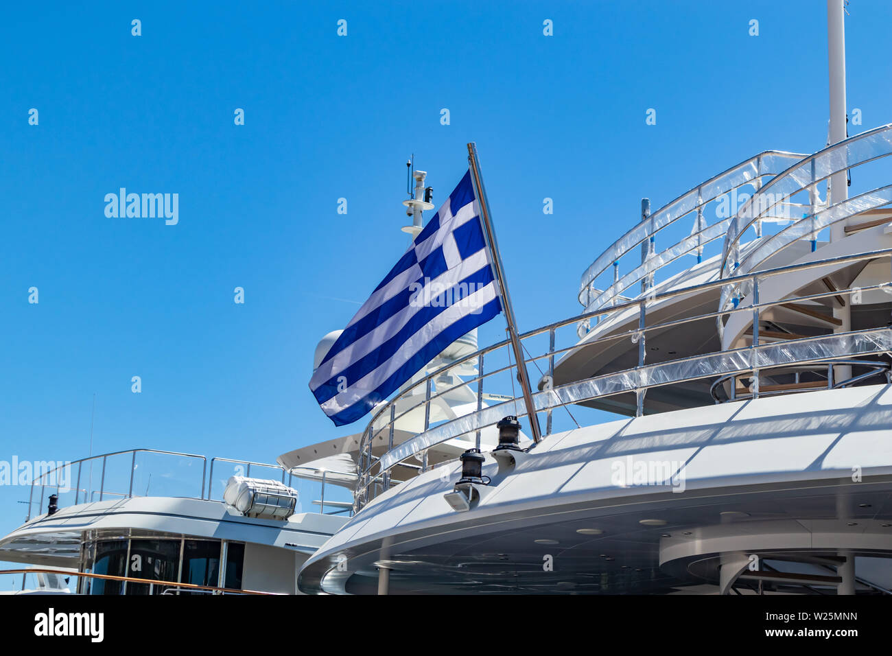 Drapeau grec sur bateau yacht de Stern. Croisière en cours en Grèce. Fond de Ciel bleu et clair, vue en gros plan. Banque D'Images