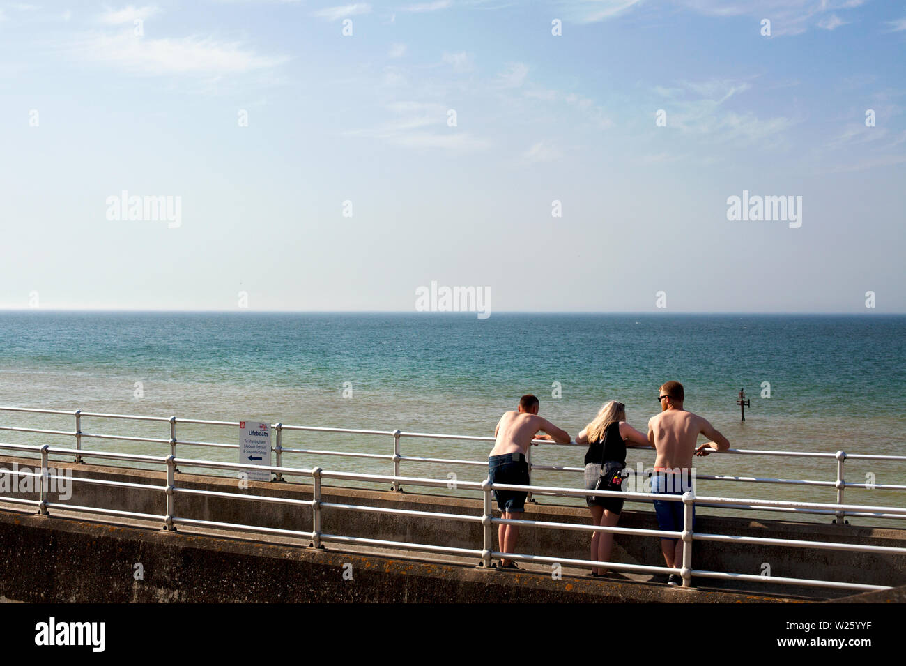 Trois jeunes gens face à la mer, Banque D'Images