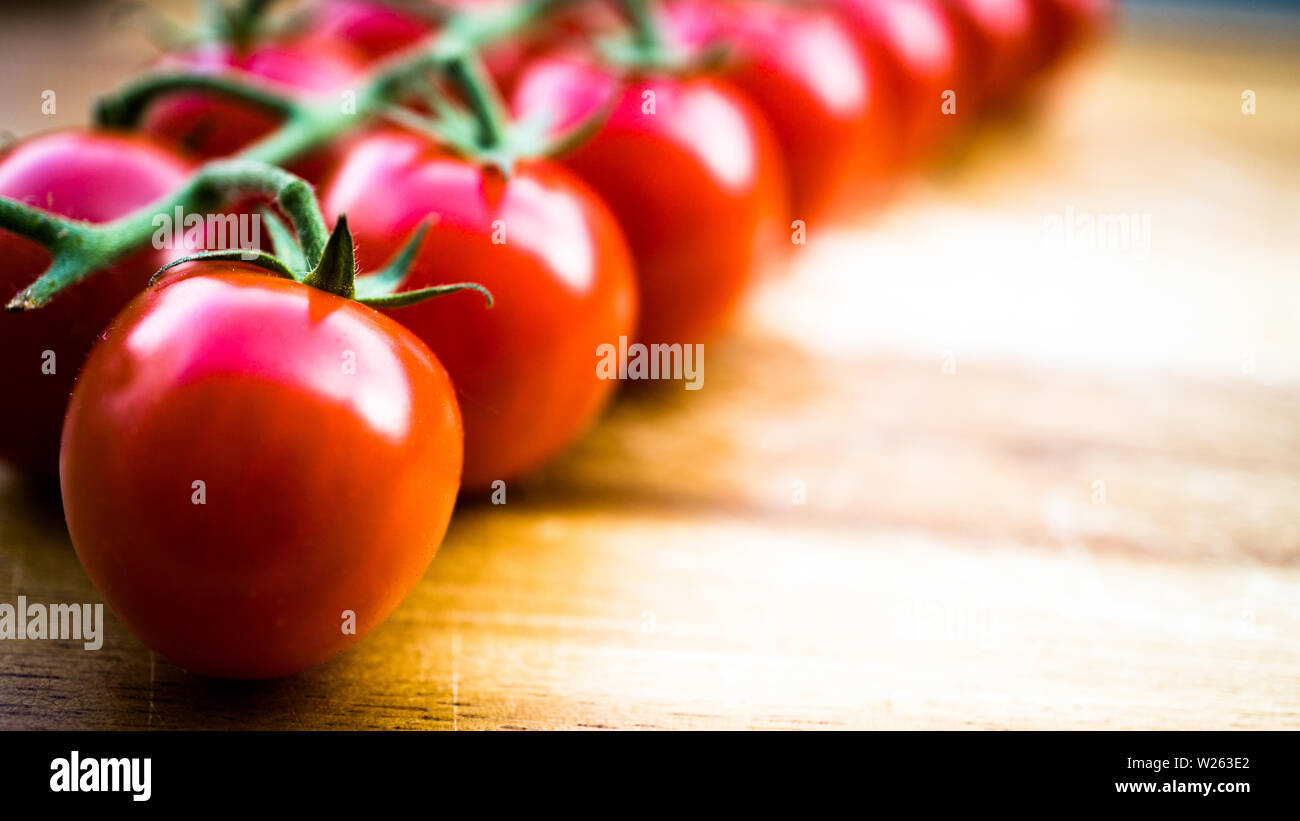 Red juicy tomates sur une planche à découper Banque D'Images