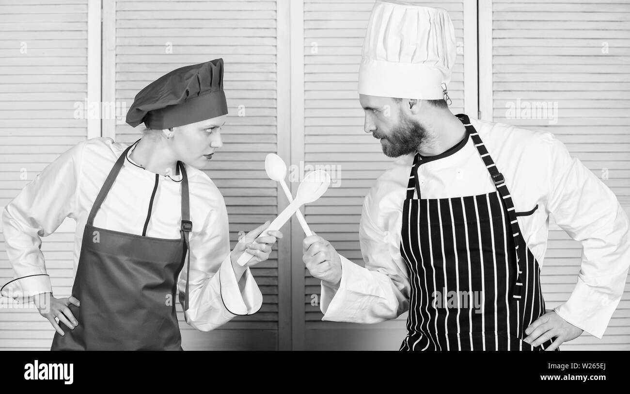 Bataille de deux chefs culinaires. Couple en compétition en arts culinaires Cuisine règles. Bataille culinaire concept. Femme et homme barbu show culinaire concurrents. Qui mieux cuisiner. Cuisine ultime défi. Banque D'Images