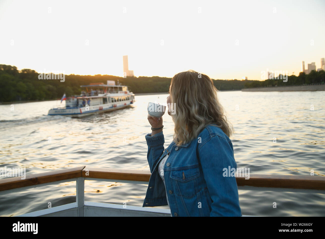 Bel'boire du thé pendant le voyage en bateau sur la rivière de Moscou. Coucher du soleil d'été. Voyager en Russie concept. Banque D'Images