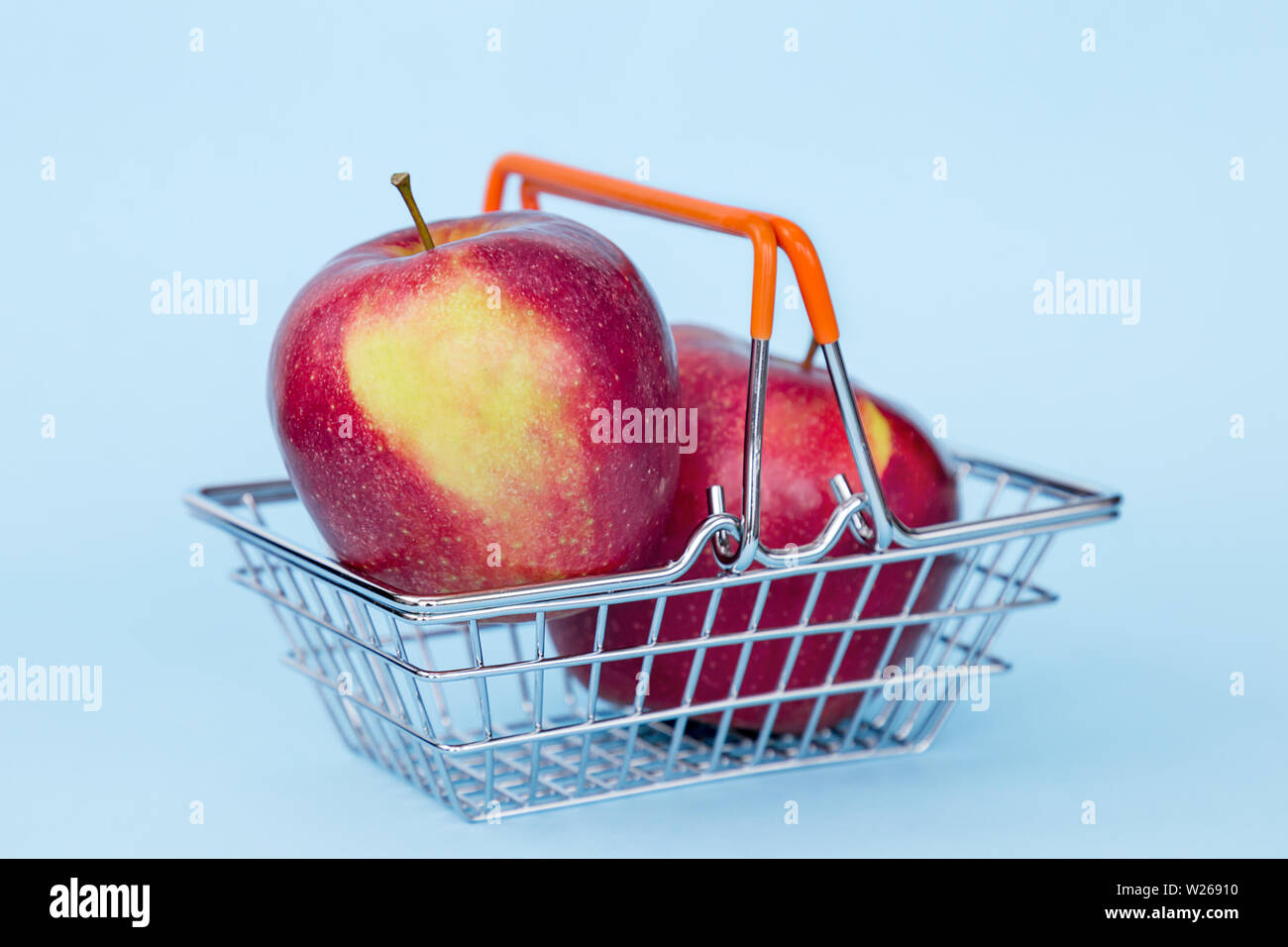 Pomme rouge dans le panier sur un fond de couleur bleu Banque D'Images