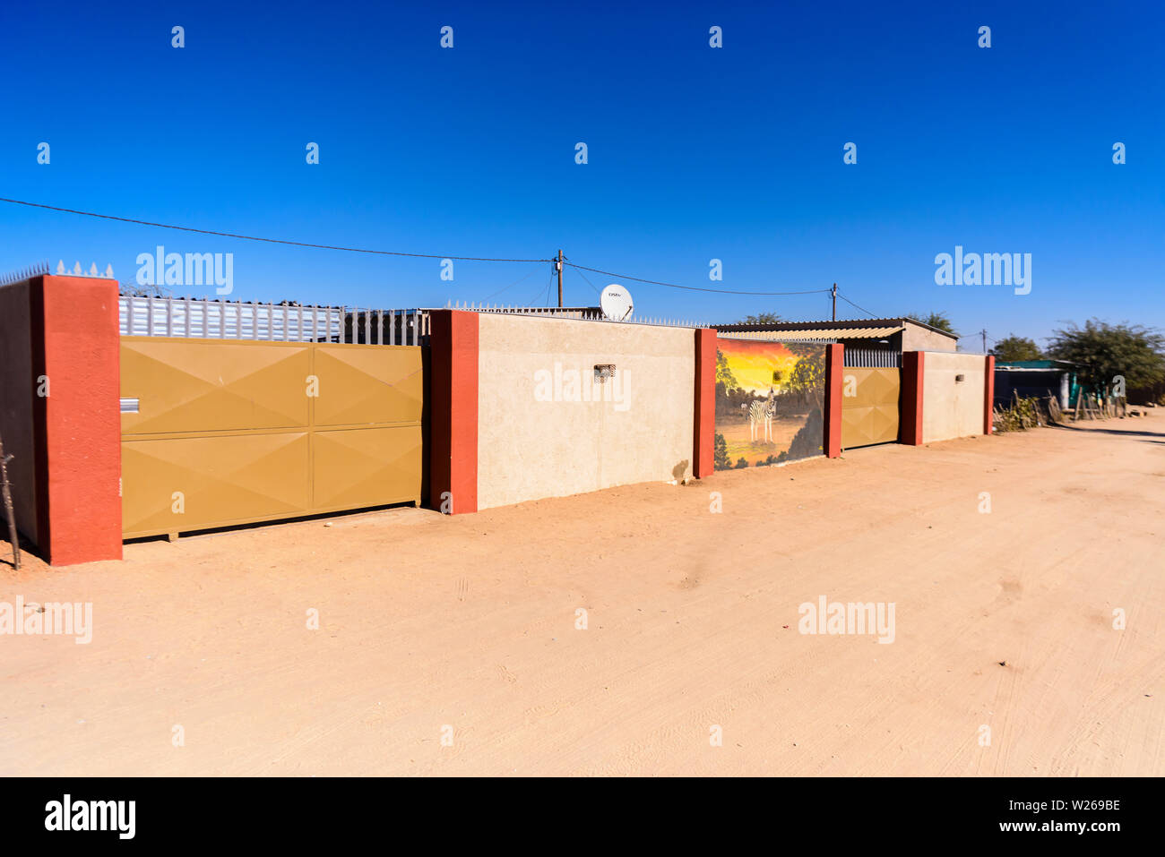 Chambre avec un grand mur, portes, une peinture murale d'un zèbre et de pointes dans une ville située à la périphérie d'Otjiwarongo, Namibie Banque D'Images