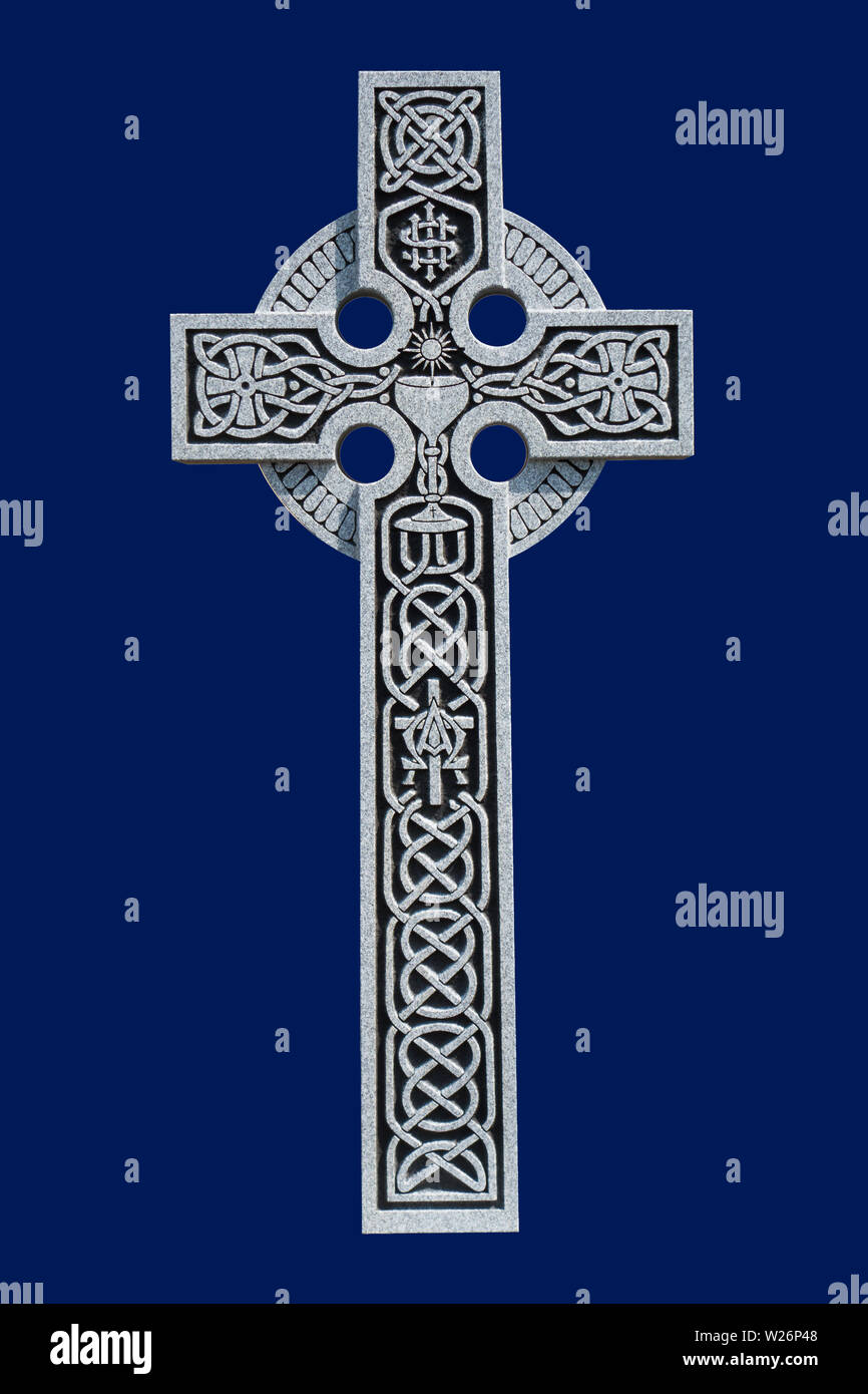 Une croix celtique en granit de la tombe d'un prêtre catholique romain, montrant le motif noeud celtique, d'une communion calice, symbole et de l'IHS Banque D'Images
