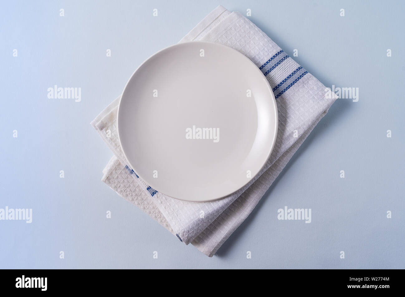 Arrière-plan de l'alimentation mise à plat avec plaque blanche vide, serviette, sur fond bleu clair. Banque D'Images