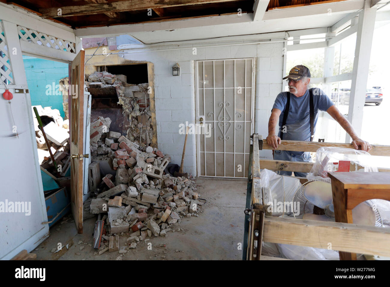 Eugene Johnson, droite, regarde la cheminée détruite par un tremblement de terre Samedi 6 juillet 2019, à son domicile de trona, Californie équipages dans le sud de la Californie a évalué les dommages à des bâtiments brûlés et fissuré, cassé les routes, les fuites d'eau et les conduites de gaz et d'autres infrastructures samedi après le plus grand séisme la région a vu en près de 20 ans ébranlé une zone de Sacramento à Las Vegas pour le Mexique. (AP Photo/Marcio Jose Sanchez) Banque D'Images