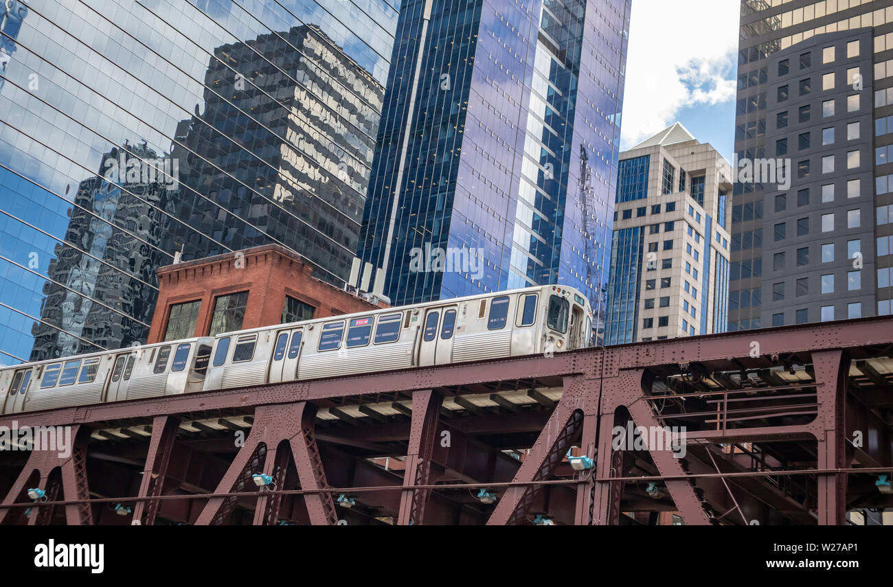 Chicago cityscape, journée de printemps. Chicago train sur un pont en fer, au centre-ville sur fond d'immeubles de grande hauteur, low angle view Banque D'Images