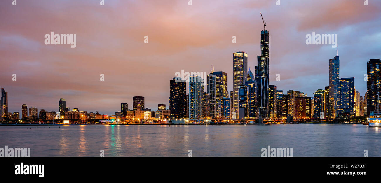 Chicago skyline panorama, l'heure du coucher du soleil. Vue panoramique du front de mer de la ville de Chicago gratte-ciel lumineux, ciel nuageux dans la soirée Banque D'Images