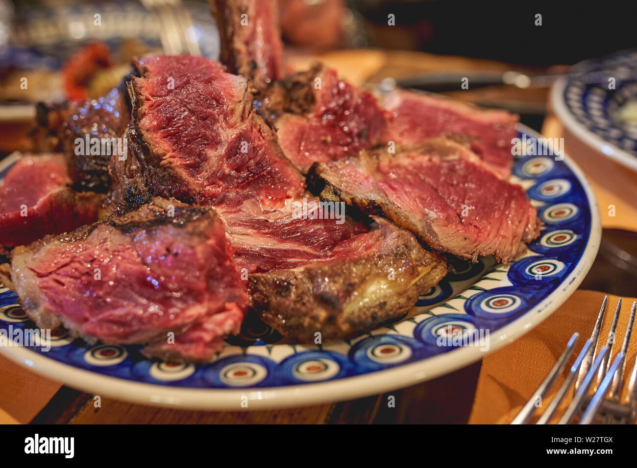 Couper un steak florentin (Bistecca alla Fiorentina), un steak d'aloyau de fait de style florentin. Le format paysage. Banque D'Images