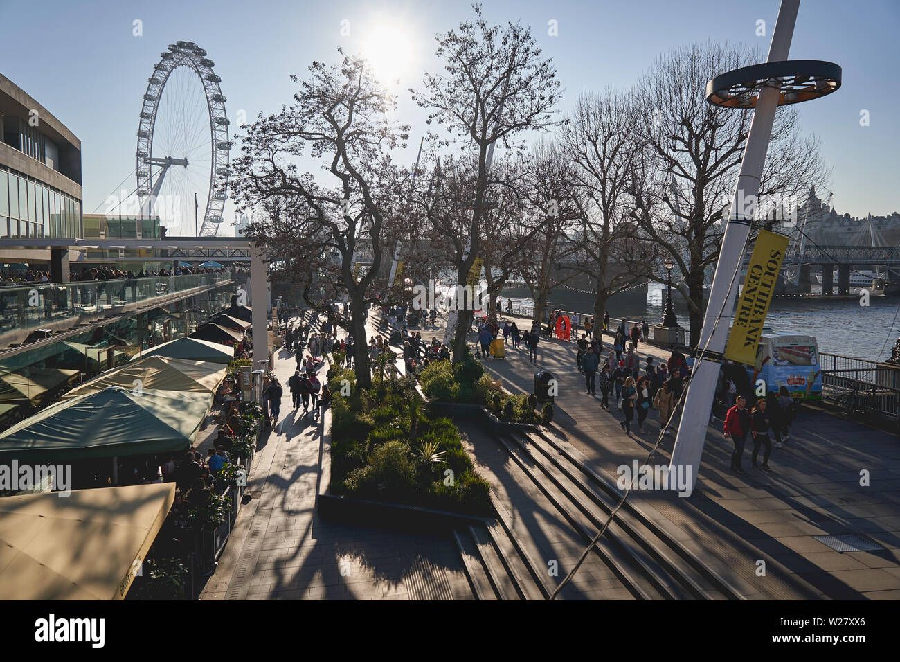 Londres, UK - Mars, 2019. Vue d'un touriste de monde Rive sud près de la Royal Festival Hall avec le London Eye sur l'arrière-plan. Banque D'Images