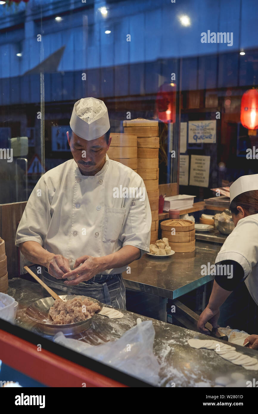 Londres, UK - avril 2019. Un homme la préparation faire cuire les boulettes dans un restaurant à China Town à Soho. Banque D'Images