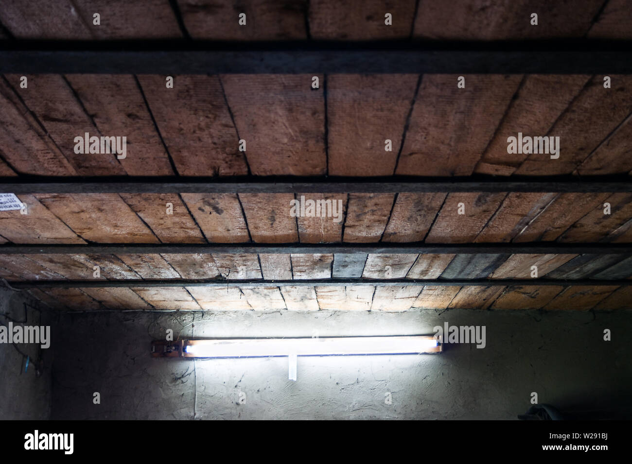 Ancien Atelier des planches de plafond avec des poutres en acier et une lampe fluorescente Lumière du jour sur une paroi. Banque D'Images