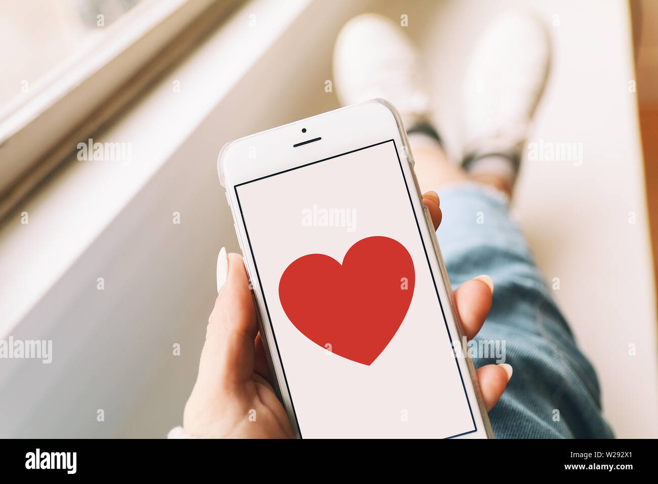 Téléphone mobile avec un coeur d'amour à l'écran Photo Stock - Alamy