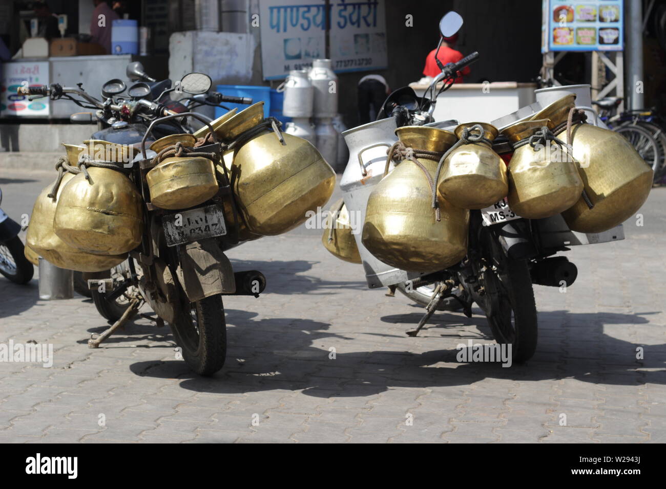 Beaucoup de lait de conserve accroché sur deux motos dans Ajmer, Rajasthan, Inde Banque D'Images