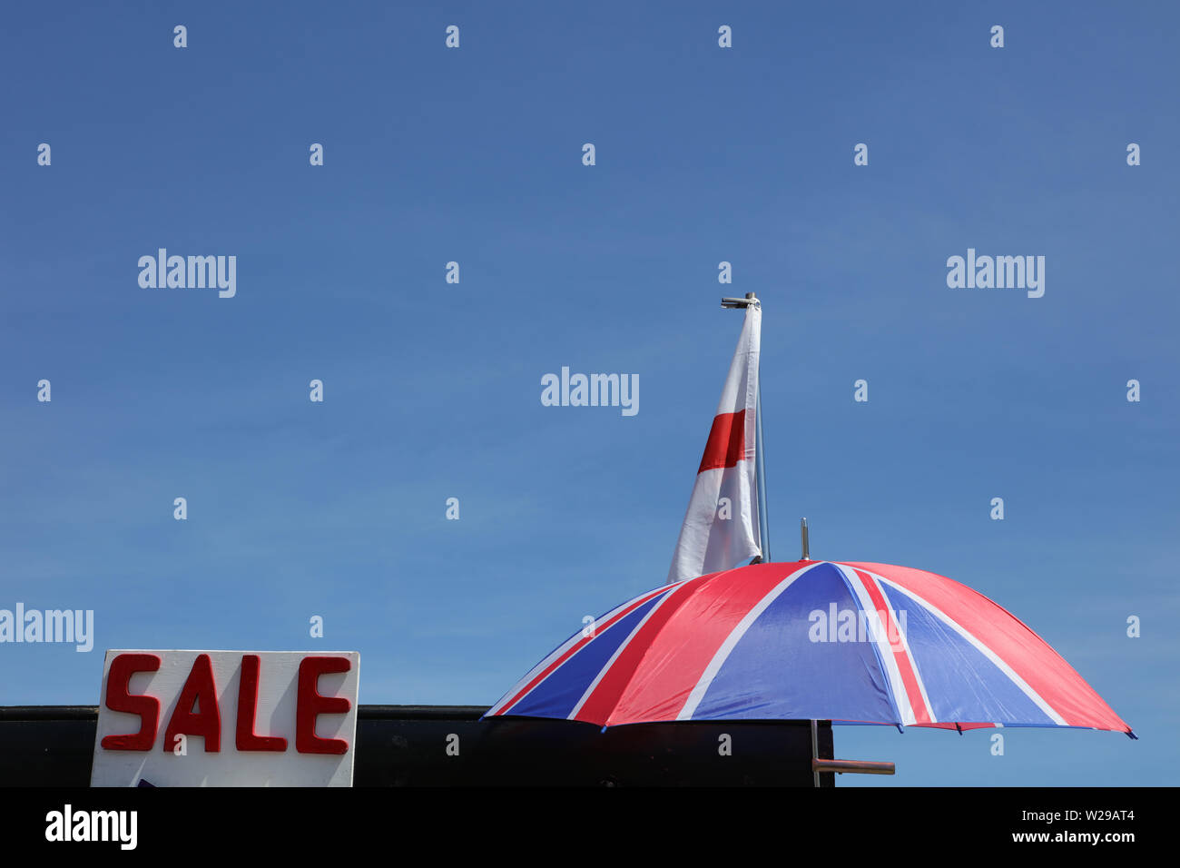 Parapluie couleurs Union Jack, le drapeau anglais et une vente signer  imputées sur le ciel bleu sur une chaude journée ensoleillée à Londres, au  Royaume-Uni Photo Stock - Alamy