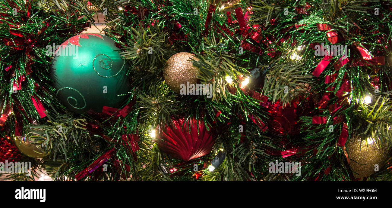 Arrière-plan de vacances festives. Arbre de Noël décoré avec des ornements et éclairés avec des lumières multicolores dans l'orientation panoramique Banque D'Images