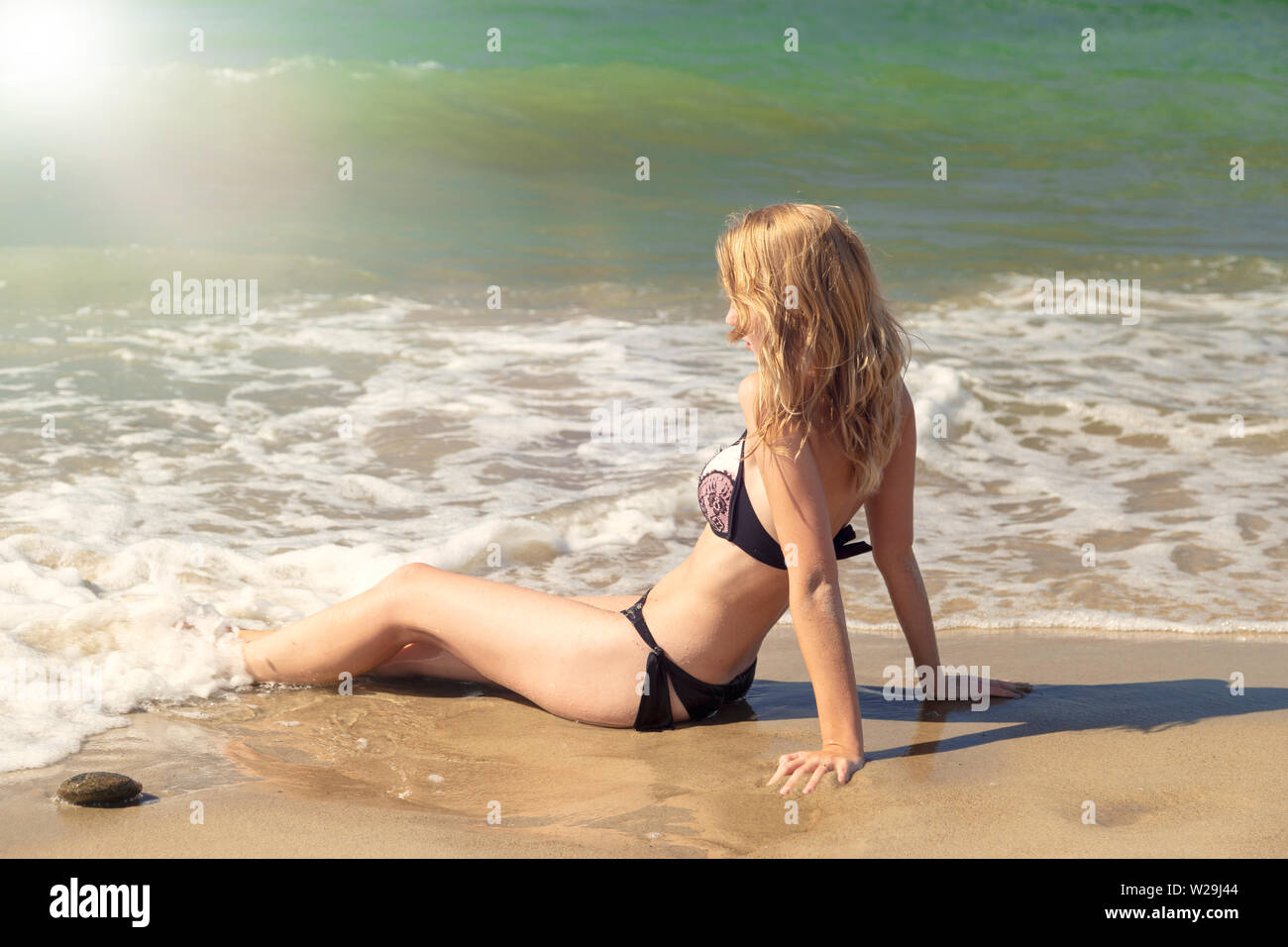 Jeune femme blonde en maillot de bain en mer surf avec mousse assis Photo  Stock - Alamy