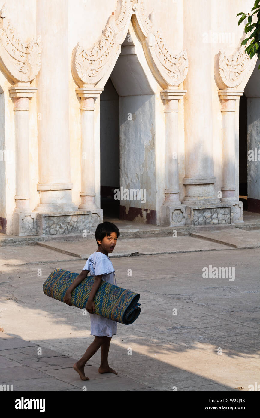 Bagan, Myanmar - Mars 2019 : l'enfant en bambou laminé mat en arrière-cour du temple Ananda à Bagan Banque D'Images