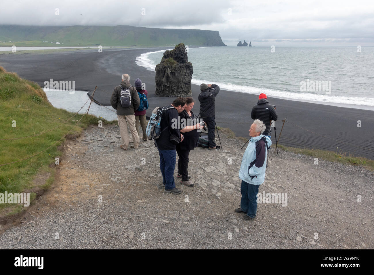 Les visiteurs de la péninsule et Kirkjufjara Plage Reynisfjara qui jouit, dans le sud de l'Islande avec la distance de Reynisdrangar. Banque D'Images