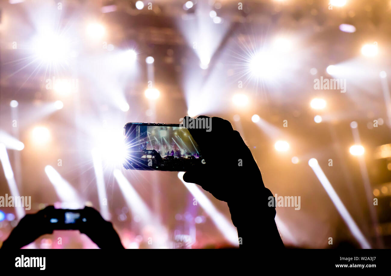 La collecte de mémoire numérique perd de capacité d'être présent, silhouette de personnes l'événement de prise de concert avec les téléphones mobiles Banque D'Images