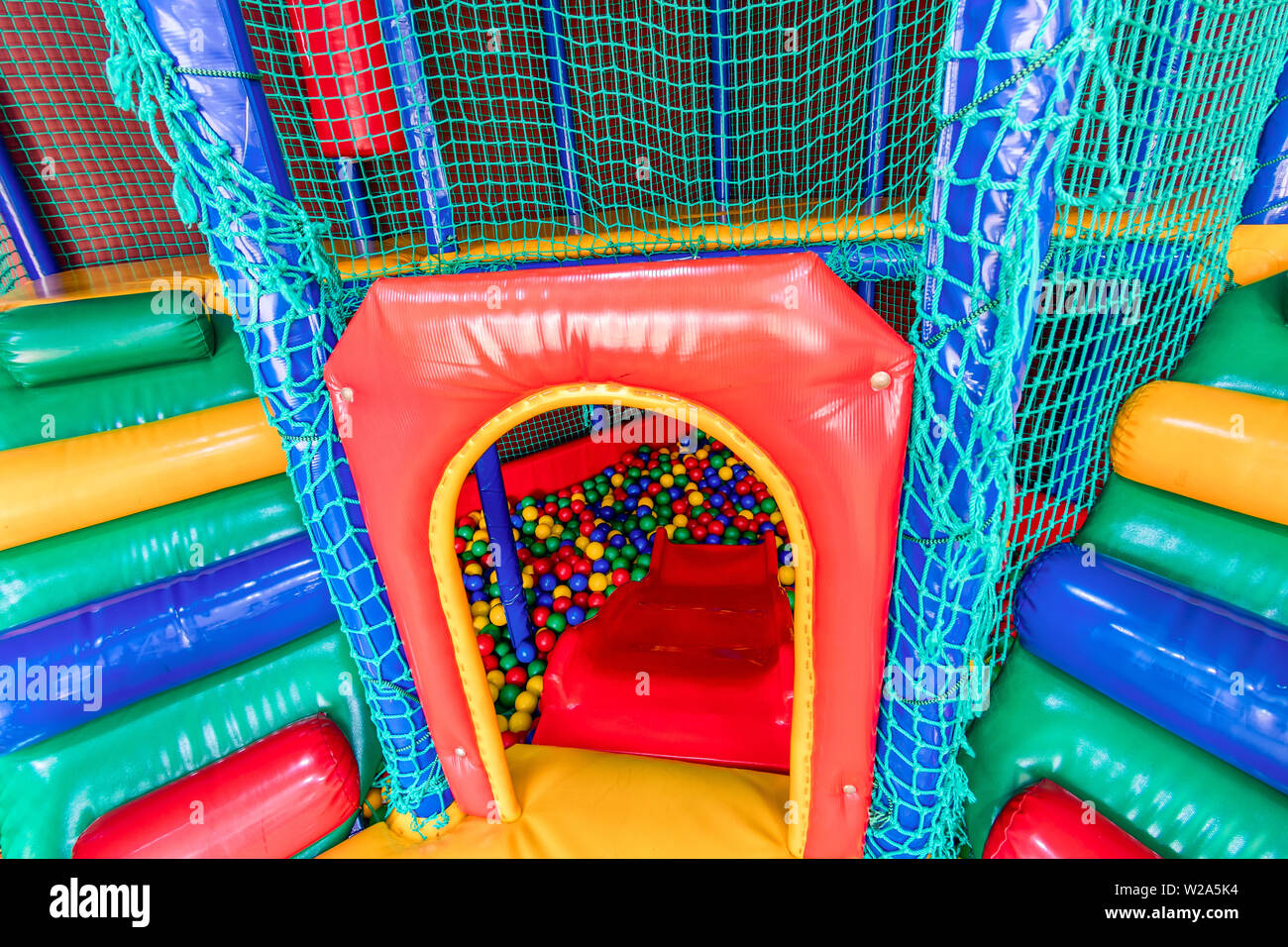 Billes en plastique de couleur dans la piscine d'une salle de jeux. Piscine pour l'amusement et de sauter dans des boules en plastique de couleur Banque D'Images