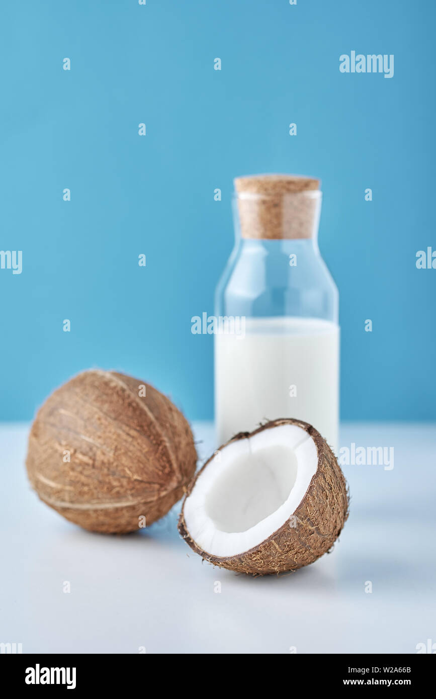 Le Lait De Coco En Bouteille En Verre Et De Coco Fraîche Avec La Moitié Sur  Fond Bleu Photo Stock - Alamy