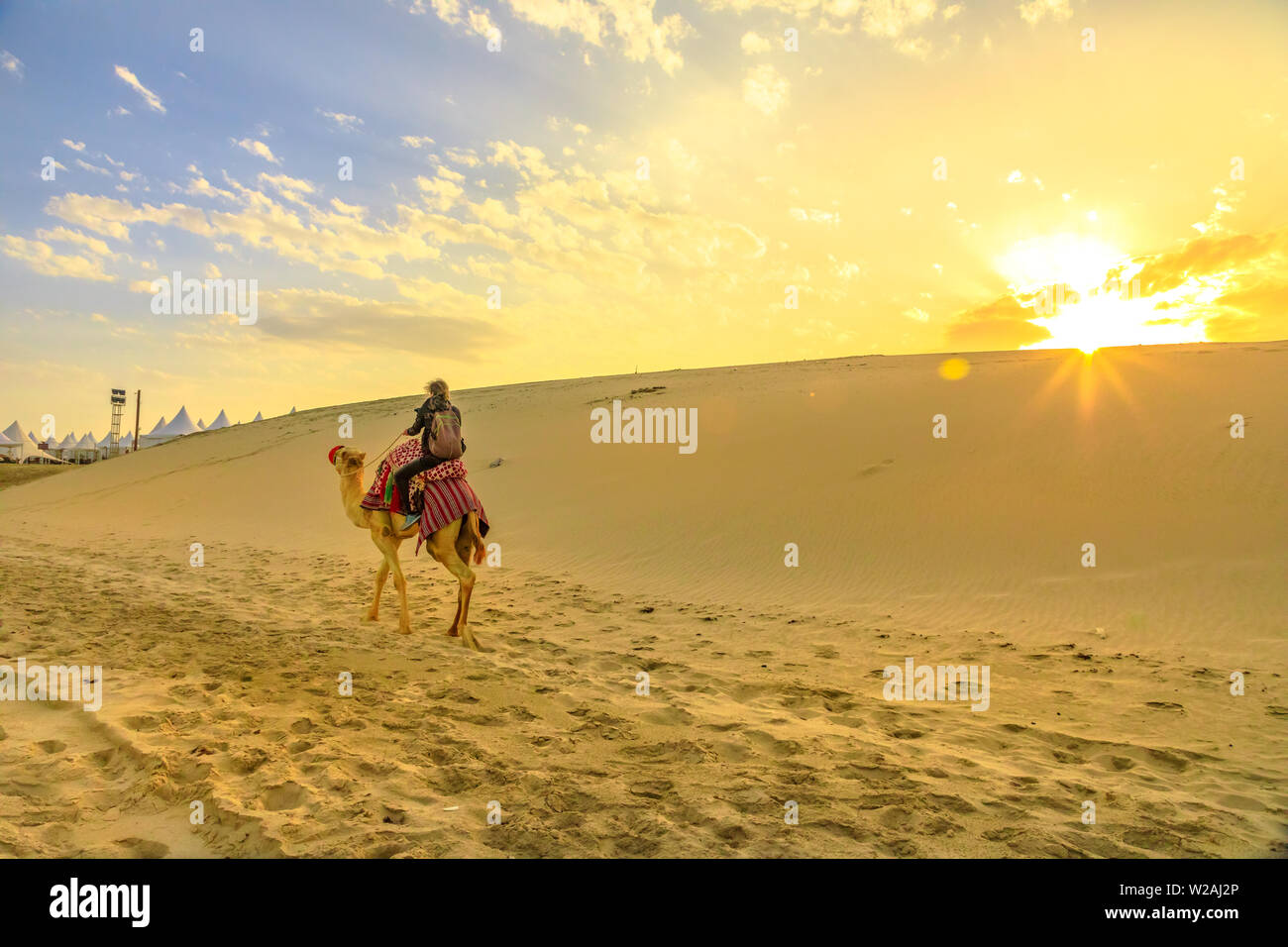 Safari dans le désert au Qatar. Meilleur homme monter un chameau sur les dunes de sable de plage de Khor al Udaid au golfe Persique. Touriste jouit d'chameau au coucher du soleil Banque D'Images
