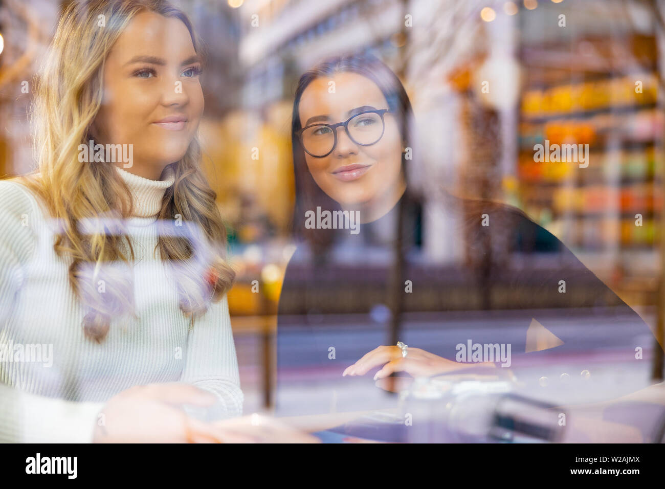 Smiling Women Talking and looking at Cafe in City Banque D'Images