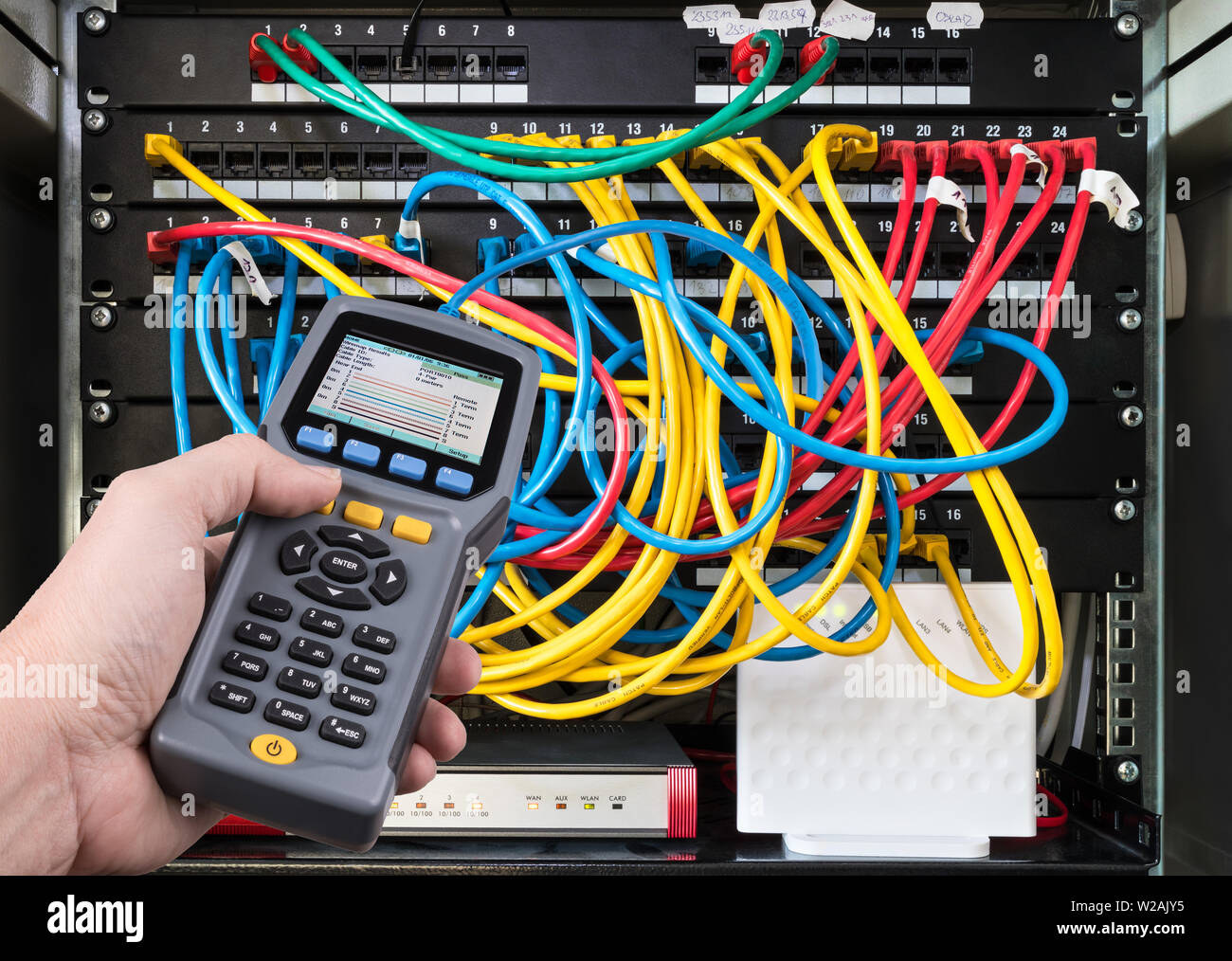 Test du réseau. Tests des performances du qualifié dans la main de détails. Mesure des signaux de données. Câbles colorés connecté dans les tableaux de connexions de rack case. Banque D'Images