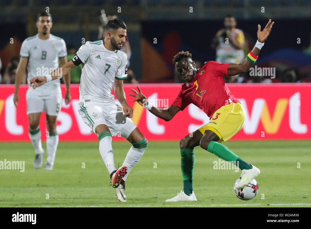 Le Caire, Égypte. 07Th Juillet, 2019. L'Algérie s'acharne pour Riyad Mahrez la balle avec la Guinée Issiaga Sylla lors de la coupe d'Afrique des Nations 2019 ronde de 16 match de football entre l'Algérie et la Guinée au stade du 30 juin. Credit : Gehad Hamdy/dpa/Alamy Live News Banque D'Images