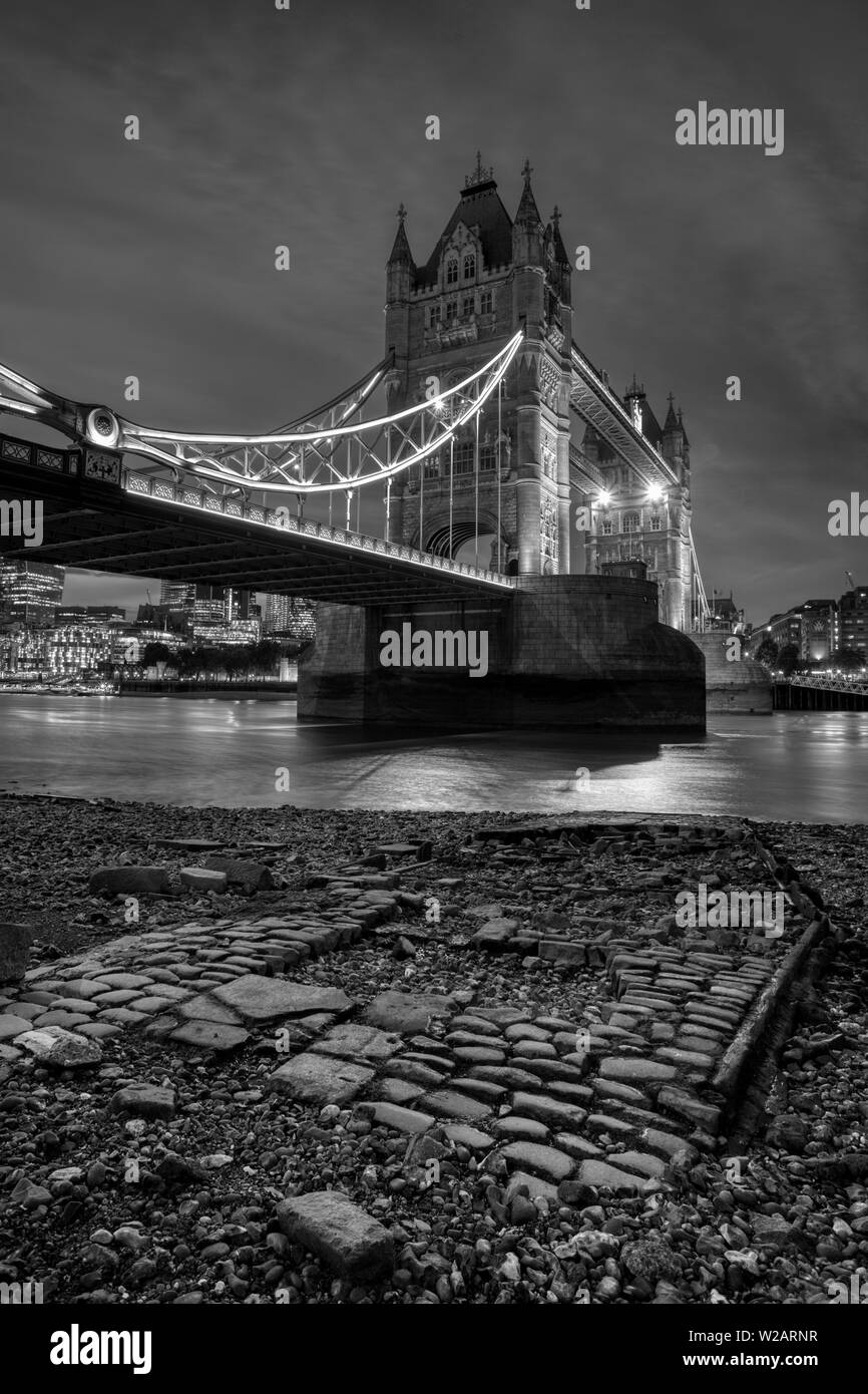 Tower Bridge, Londres, l'emblématique pont qui enjambe la Tamise, photographié de nuit, image en noir et blanc Banque D'Images