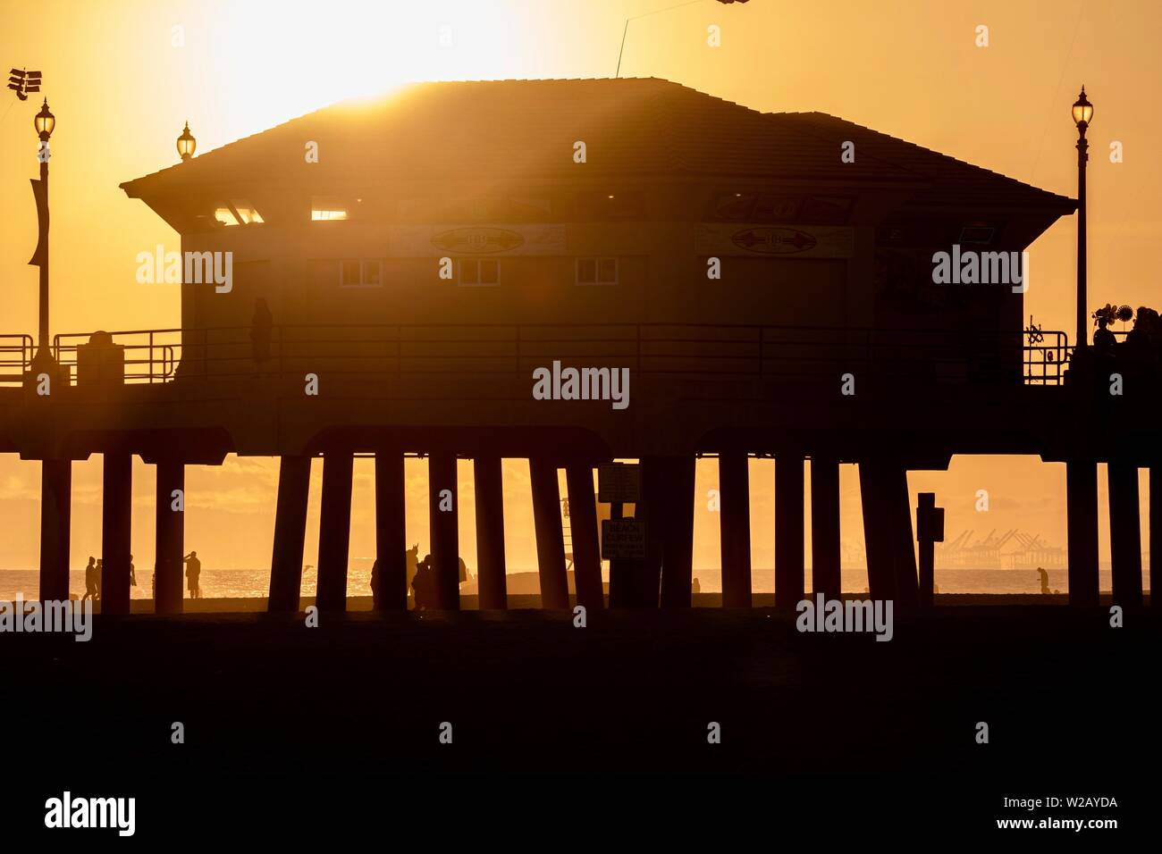 Silhouettes de gens sur le Huntington Beach Pier pendant le coucher du soleil Banque D'Images