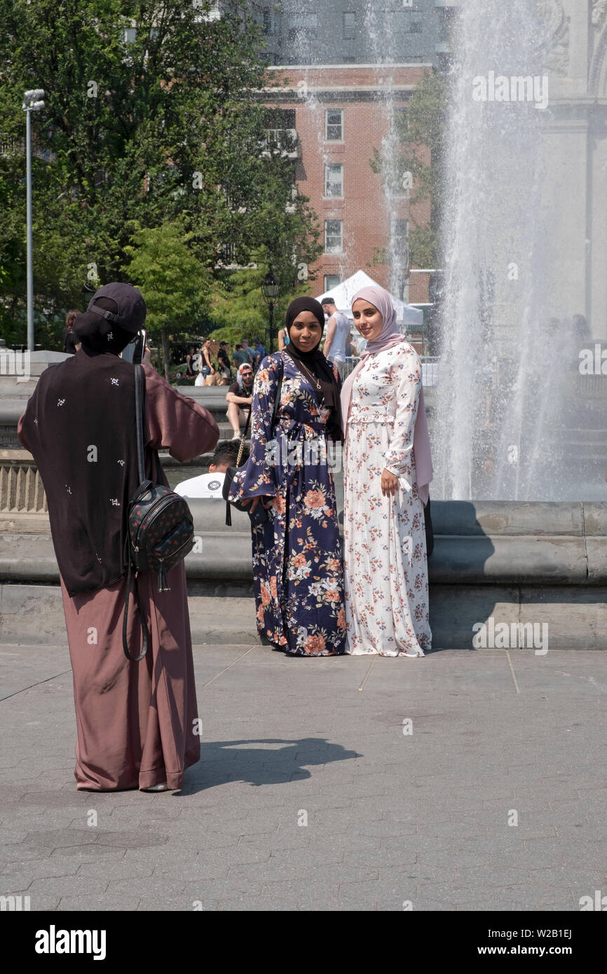 Deux femmes musulmanes dans un hijab longues posent pour une photo touristique près de la fontaine à Washington Square Park à Greenwich Village, New York City. Banque D'Images