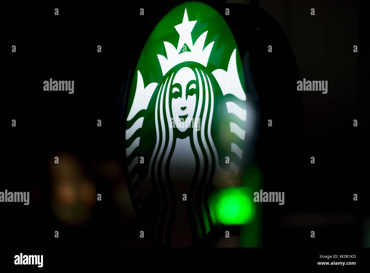 MINNEAPOLIS, MINNESOTA / USA - 3 juillet 2019 : signe de Starbucks allumé sur une nuit d'été à Minneapolis avec des lumières de rue reflétée sur la fenêtre Banque D'Images