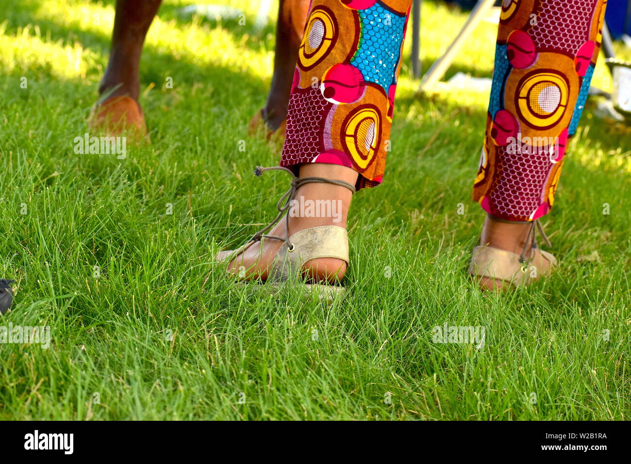 Tir bas de African woman walking avec pantalon africain traditionnel Banque D'Images