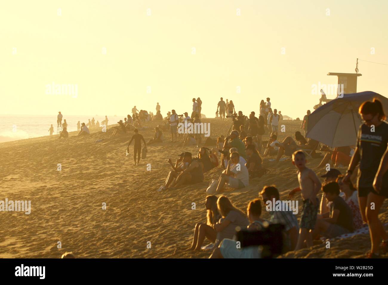 Spectateurs de la plage de coin à Newport Beach Californie regarder les surfeurs et bodyboarders dans l'océan Banque D'Images