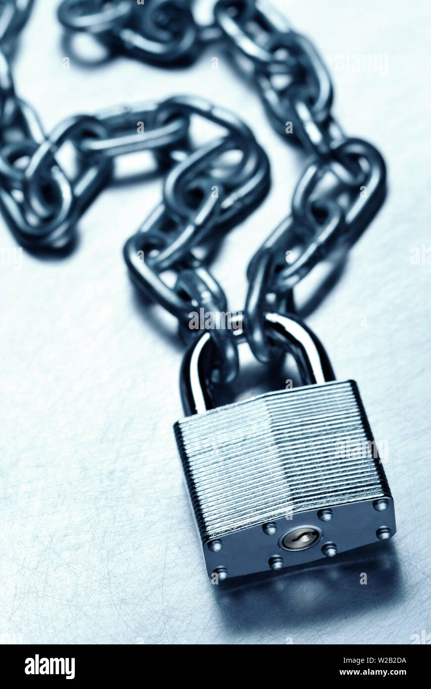 Concept de sécurité montrant des cadenas en acier solide et la chaîne sur la surface en acier rayé Banque D'Images