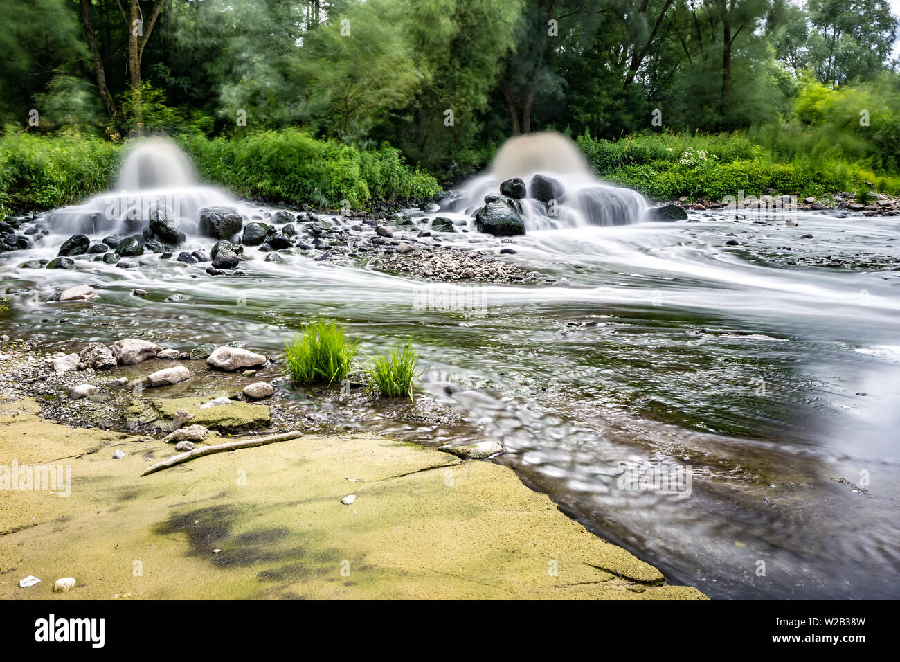 La zone de mélange des eaux usées des égouts urbains. la pollution des décharges de la ville. Une longue exposition. Banque D'Images