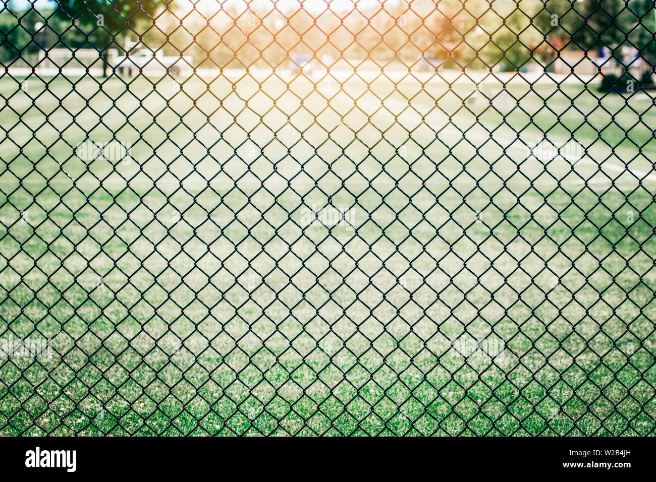 Gros plan du filet black metal wire mesh fence contre champ vert prairie.  Arrière-plan de surface texture pattern chain link rabitz en maille Photo  Stock - Alamy