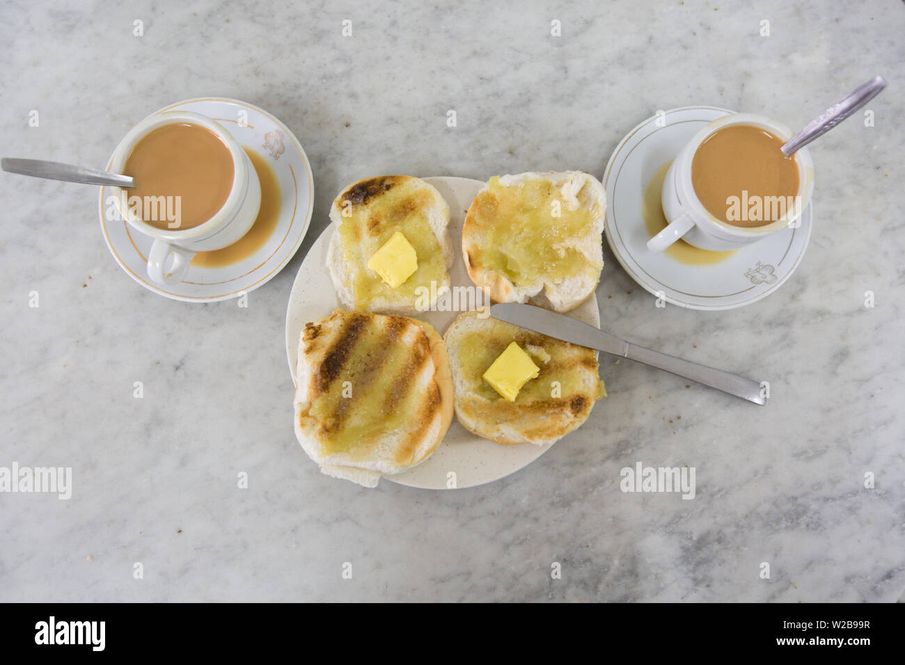 Boulangerie traditionnelle qui ont 2 tasses de thé et une assiette de bun à partir d'une perspective de high point Banque D'Images